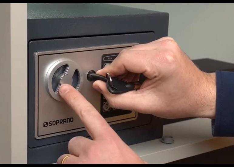 Profissional abrindo cofre com chave na fechadura do equipamento