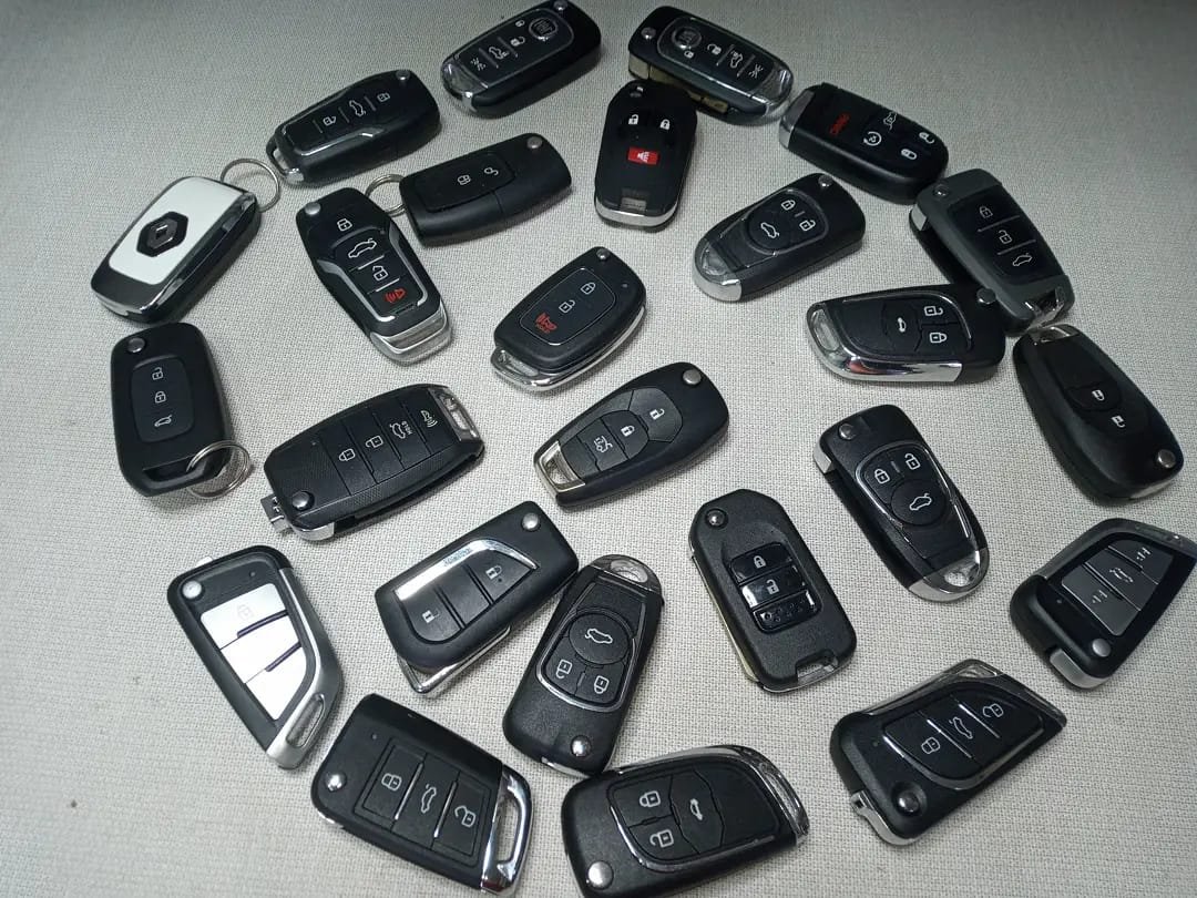 Diversas chaves canivete automotivas de vários modelos sobre uma superfície clara